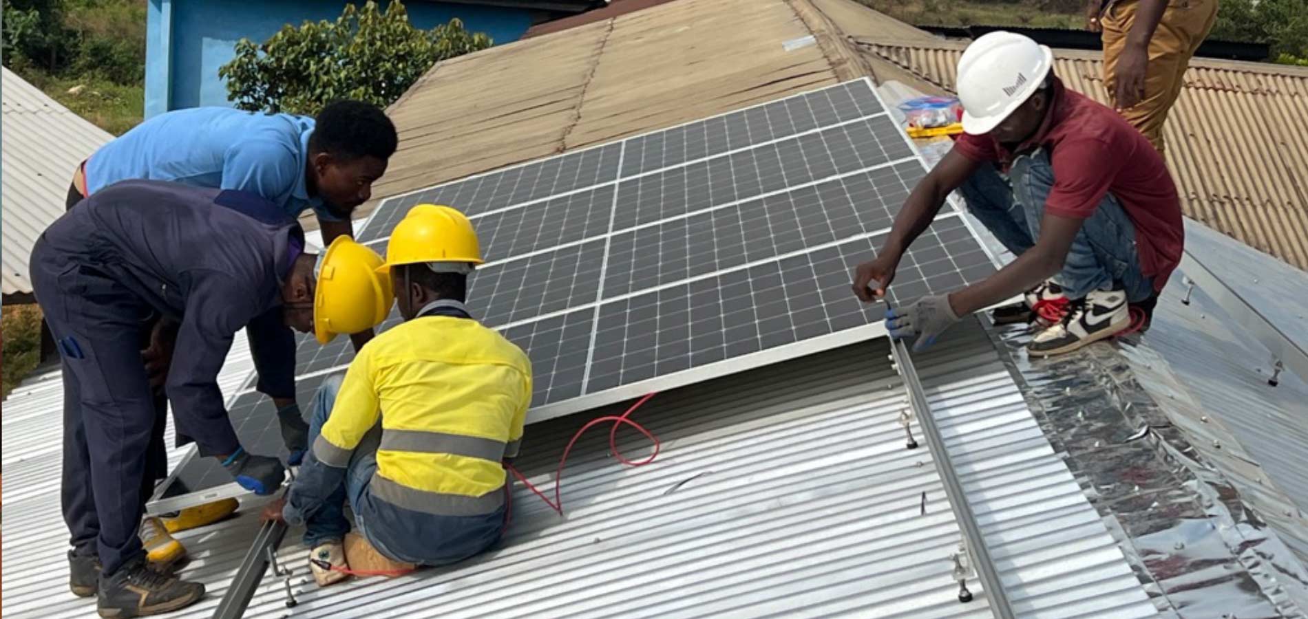 Solar panels for the computer classroom are installed by SLOIC electrical students.